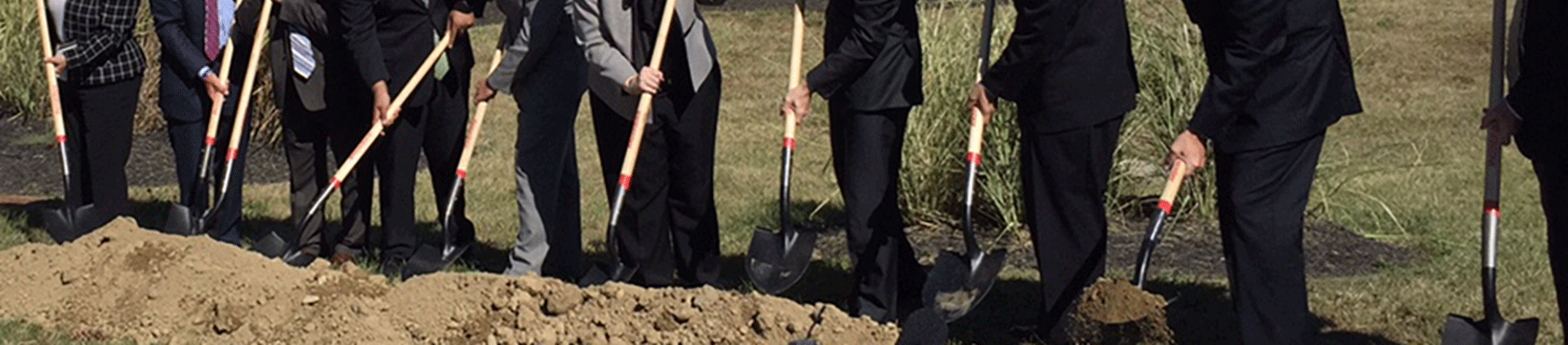 Group breaking construction ground with shovels