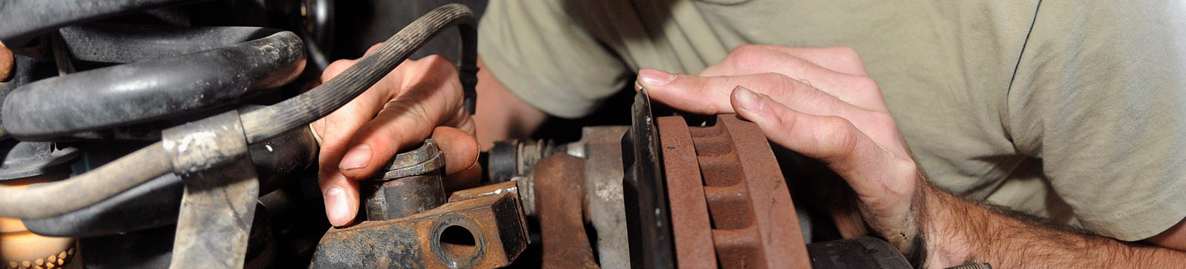 Hands working on automobile suspension